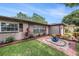 Attractive single-story home with colorful landscaping, brick accents, and a tranquil fountain feature at 1179 Lazy Lake W Rd, Dunedin, FL 34698