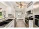 Modern kitchen with white cabinetry, stainless steel appliances, and stylish tile backsplash at 1179 Lazy Lake W Rd, Dunedin, FL 34698