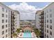 Aerial view showcasing building exterior and outdoor pool area with palm trees and lounge chairs at 1208 E Kennedy Blvd # 831, Tampa, FL 33602