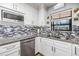 Modern kitchen featuring granite countertops, stainless steel appliances, tiled backsplash, and ample cabinetry at 1225 15Th St, Palm Harbor, FL 34683