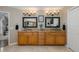 Elegant bathroom with double vanity, granite counters, dark framed mirrors, and sconce lighting at 1228 Dartford Dr, Tarpon Springs, FL 34688