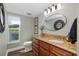 Half bathroom with stylish vanity, oval mirror, and a view of the pond at 1228 Dartford Dr, Tarpon Springs, FL 34688