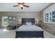 Inviting bedroom with a wood accent wall, ceiling fan, and a window overlooking the outdoors at 1228 Dartford Dr, Tarpon Springs, FL 34688