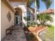 Inviting entrance with lush landscaping, a decorative bench, and arched doorway at 1228 Dartford Dr, Tarpon Springs, FL 34688