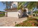 Well-maintained two-story home with a brick driveway and beautiful landscaping at 1228 Dartford Dr, Tarpon Springs, FL 34688