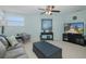 Bright living room featuring neutral décor, a comfortable sofa, and a television, creating a welcoming and relaxing space at 1228 Dartford Dr, Tarpon Springs, FL 34688