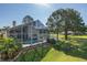 Backyard view of screened-in pool area, with mature trees, and partial view of the pond at 1228 Dartford Dr, Tarpon Springs, FL 34688