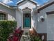 Front door view of home with well-manicured landscaping and a teal-colored front door at 12713 Whitney Meadow Way, Riverview, FL 33578