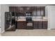 Kitchen featuring stainless steel appliances, dark cabinets, and a tile backsplash at 12713 Whitney Meadow Way, Riverview, FL 33578