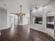 Open-concept living room featuring wood floors, neutral paint, elegant archways, and views of the entryway and kitchen at 12713 Whitney Meadow Way, Riverview, FL 33578