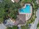 Aerial view of a community pool surrounded by trees, offering a refreshing oasis and lounge area at 12713 Whitney Meadow Way, Riverview, FL 33578