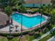 Community pool with lounge chairs, tables, umbrellas, and palm trees creates a tropical resort feel at 12713 Whitney Meadow Way, Riverview, FL 33578
