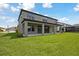 Expansive backyard with covered patio, lush green grass, and contemporary home design at 13137 Wellspring Dr, Lithia, FL 33547