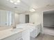 Bathroom with double vanity, white cabinets, quartz countertop, and modern fixtures at 13137 Wellspring Dr, Lithia, FL 33547