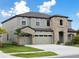 Stunning two-story home featuring stone accents, a three-car garage, and lush landscaping at 13137 Wellspring Dr, Lithia, FL 33547