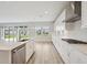 Bright, modern kitchen featuring white cabinetry, quartz countertops, and stainless steel appliances at 13137 Wellspring Dr, Lithia, FL 33547