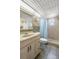 Bright bathroom featuring a tiled walk-in shower, neutral finishes, and ample lighting at 13440 Gulf Blvd # 501, Madeira Beach, FL 33708