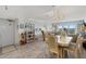 Dining room featuring a table with chairs, adjacent to living area with water view at 13440 Gulf Blvd # 501, Madeira Beach, FL 33708