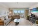 Living room featuring comfortable seating, wood-look flooring, and views of the water at 13440 Gulf Blvd # 501, Madeira Beach, FL 33708
