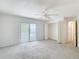 Bedroom boasts carpet, a fan, sliding glass doors to a balcony, and double-door closets at 13918 Raie Ave, Hudson, FL 34667