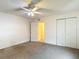 Bedroom features carpet, ceiling fan, and a closet for storage at 13918 Raie Ave, Hudson, FL 34667