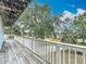 A great view from the deck with white railings and a rustic, weathered wood floor with a yard beyond at 13918 Raie Ave, Hudson, FL 34667