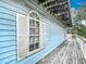 Exterior shows the deck and siding of the light blue house with white trim window and shutter detail at 13918 Raie Ave, Hudson, FL 34667