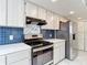 A bright kitchen with tiled floor, stainless steel appliances, and neutral color cabinets and countertops at 13918 Raie Ave, Hudson, FL 34667