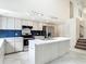 Bright, open kitchen featuring a large island, white cabinetry, stainless appliances and tile backsplash at 13918 Raie Ave, Hudson, FL 34667