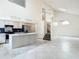 Spacious kitchen area with tall ceiling, a kitchen island with bar seating, and stairs to the second floor at 13918 Raie Ave, Hudson, FL 34667