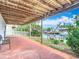 Covered patio showing waterfront canal with dock and boat lift, lush landscaping and bench seating at 13918 Raie Ave, Hudson, FL 34667