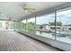 Spacious screened porch presents views of a canal, a neighbor's yard, and mature trees at 13918 Raie Ave, Hudson, FL 34667