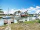 Waterfront view of boats docked in a canal near multiple homes under sunny blue skies at 13918 Raie Ave, Hudson, FL 34667