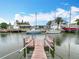 Waterfront view of a canal with multiple boats and docks and homes on either side under sunny skies at 13918 Raie Ave, Hudson, FL 34667
