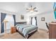 Cozy bedroom with a king-size bed, carpet flooring, two windows, and dark-blue curtains at 14510 Haddon Mist Dr, Wimauma, FL 33598