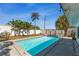 Backyard pool with a pink flamingo floatie, surrounded by green trees and a white fence at 1503 4Th St Sw, Largo, FL 33770