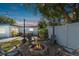 Backyard firepit with patio, string lights, white privacy fence, and jacuzzi in the background at 1503 4Th St Sw, Largo, FL 33770