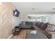 Spacious living room with large sofa, modern wood accent wall, and view to the dining room at 1503 4Th St Sw, Largo, FL 33770