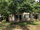 View of home featuring a covered front porch, dark shutters and mature trees at 1508 S Clark Ave, Tampa, FL 33629