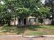 This single-story home features a covered front porch, dark shutters and mature trees at 1508 S Clark Ave, Tampa, FL 33629