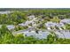 An aerial view showcasing a neighborhood with well-maintained houses, lush greenery, and mature trees at 1628 Lullwater Ln, Lutz, FL 33549