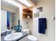 Bathroom with a unique mirror, granite counters and decorative shelving at 1628 Lullwater Ln, Lutz, FL 33549