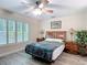 Bedroom featuring plantation shutters, ceiling fan, and wood-look flooring at 1628 Lullwater Ln, Lutz, FL 33549