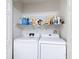 Efficient laundry room with a side-by-side washer and dryer, and overhead storage at 1628 Lullwater Ln, Lutz, FL 33549
