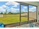 Screened lanai view of the spacious backyard with white vinyl fence at 16892 Delia St, Wimauma, FL 33598