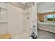 Bright shower featuring white tiles and a curtain leading to the bedroom at 16892 Delia St, Wimauma, FL 33598