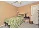 Bright bedroom with neutral walls, ceiling fan, carpet floors, and a comfortable single bed with a tropical quilt at 16892 Delia St, Wimauma, FL 33598
