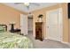 Neutral bedroom showcasing a wooden dresser, carpet floors, ceiling fan, and a comfortable bed with tropical quilt at 16892 Delia St, Wimauma, FL 33598