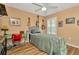Cozy bedroom featuring wood floors, a ceiling fan, and ample natural light from the window at 16892 Delia St, Wimauma, FL 33598