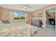 Bedroom with a large window overlooking greenery, complemented by a dresser and a ceiling fan at 16892 Delia St, Wimauma, FL 33598